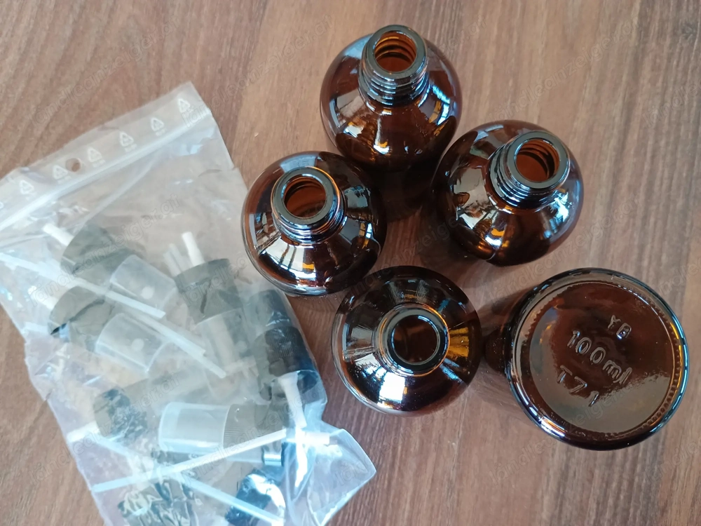 Verschiedene Braunglasfläschen und Cremetigel mit Aufsätzen