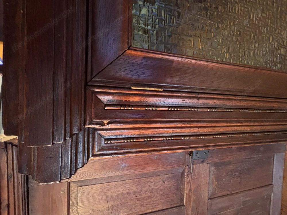 Massiver alter Schrank mit Glaselementen und Verzierung