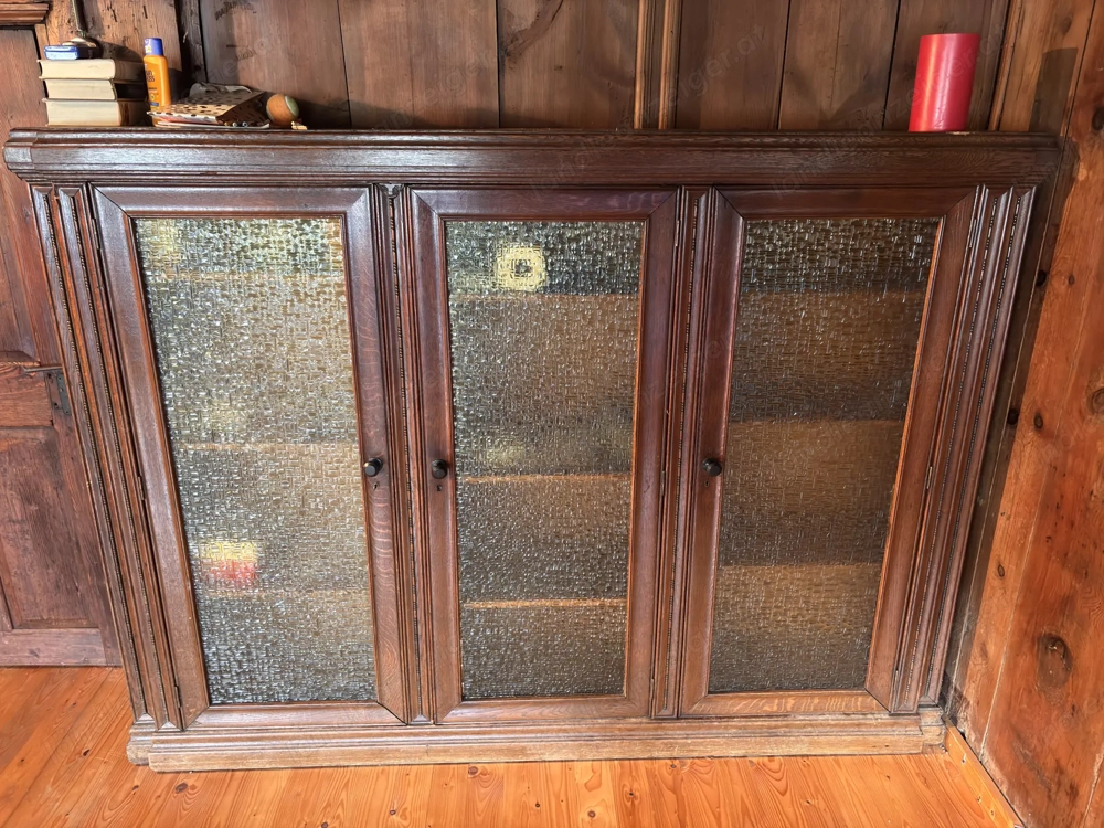 Massiver alter Schrank mit Glaselementen und Verzierung