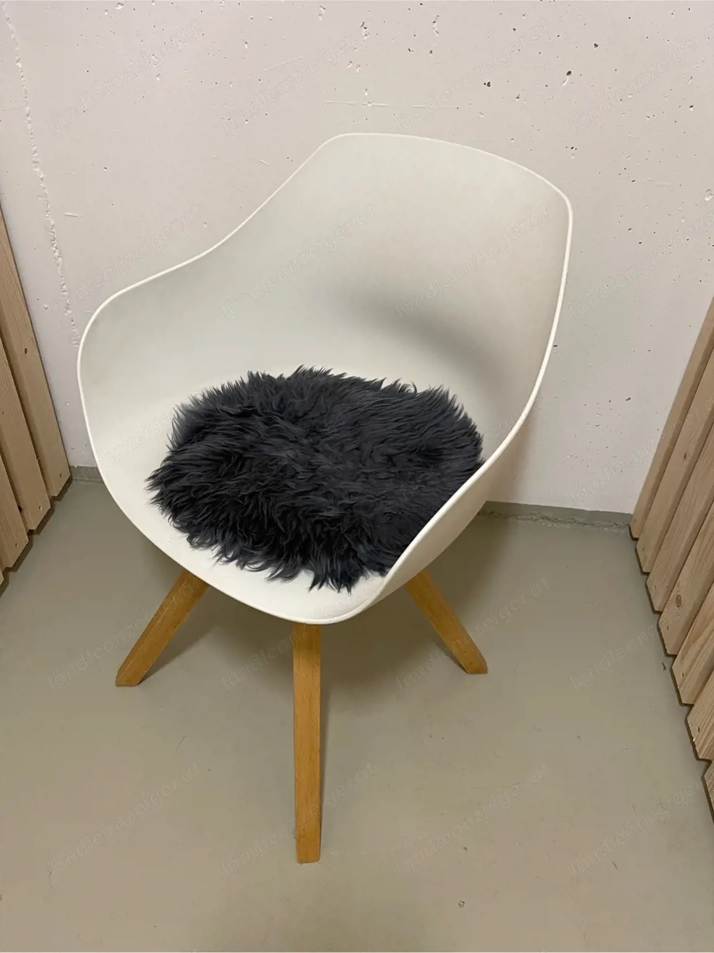 Weißer Schalenstuhl mit Fell