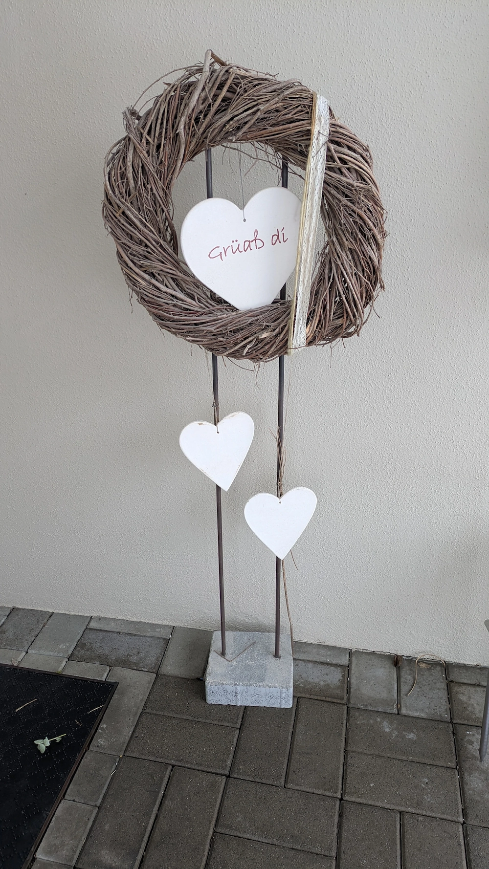 Dekoratives Steher mit Kranz und Hängeherze