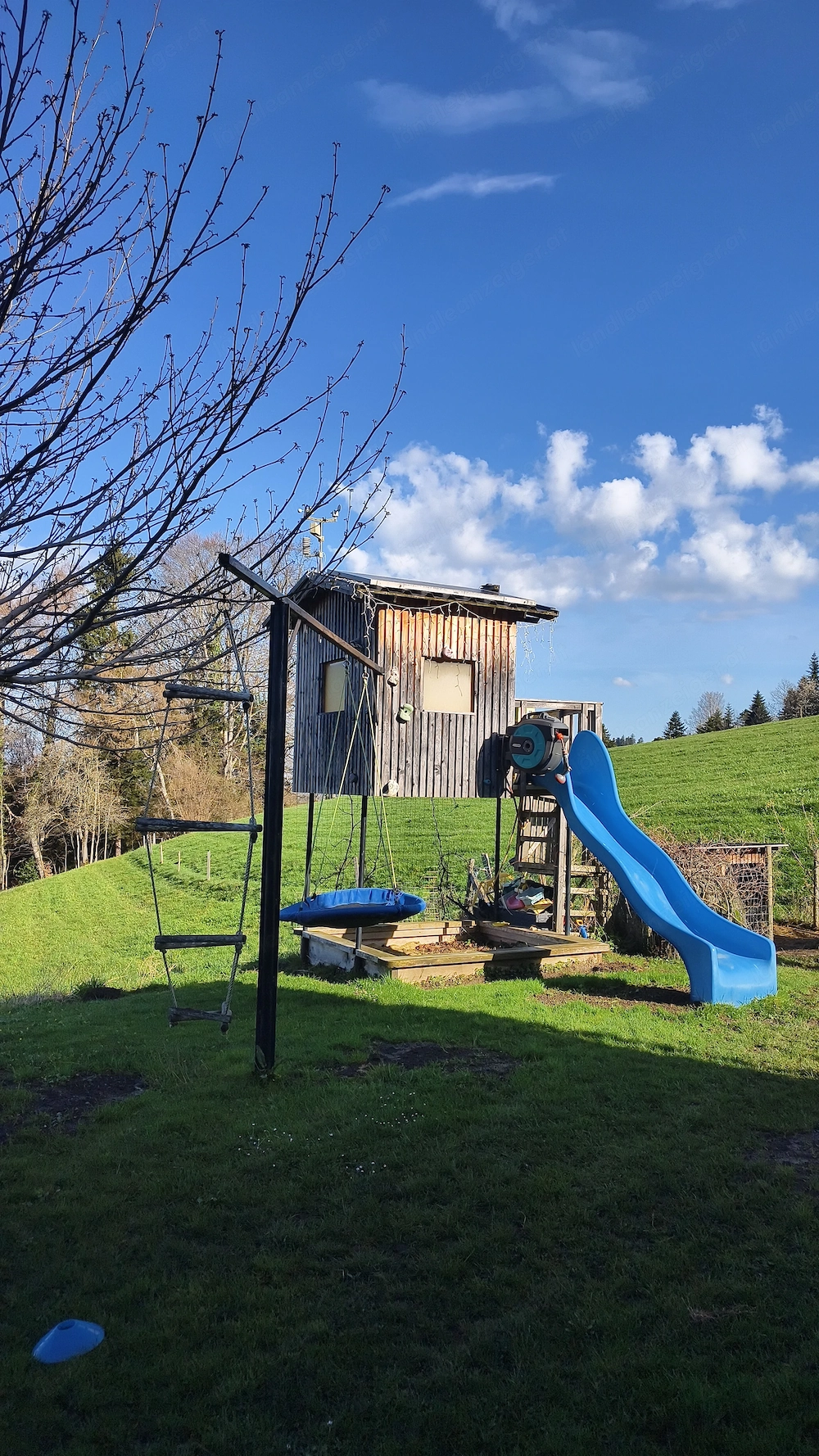 Spielhaus mit Schaukelstangen und Sandkasten