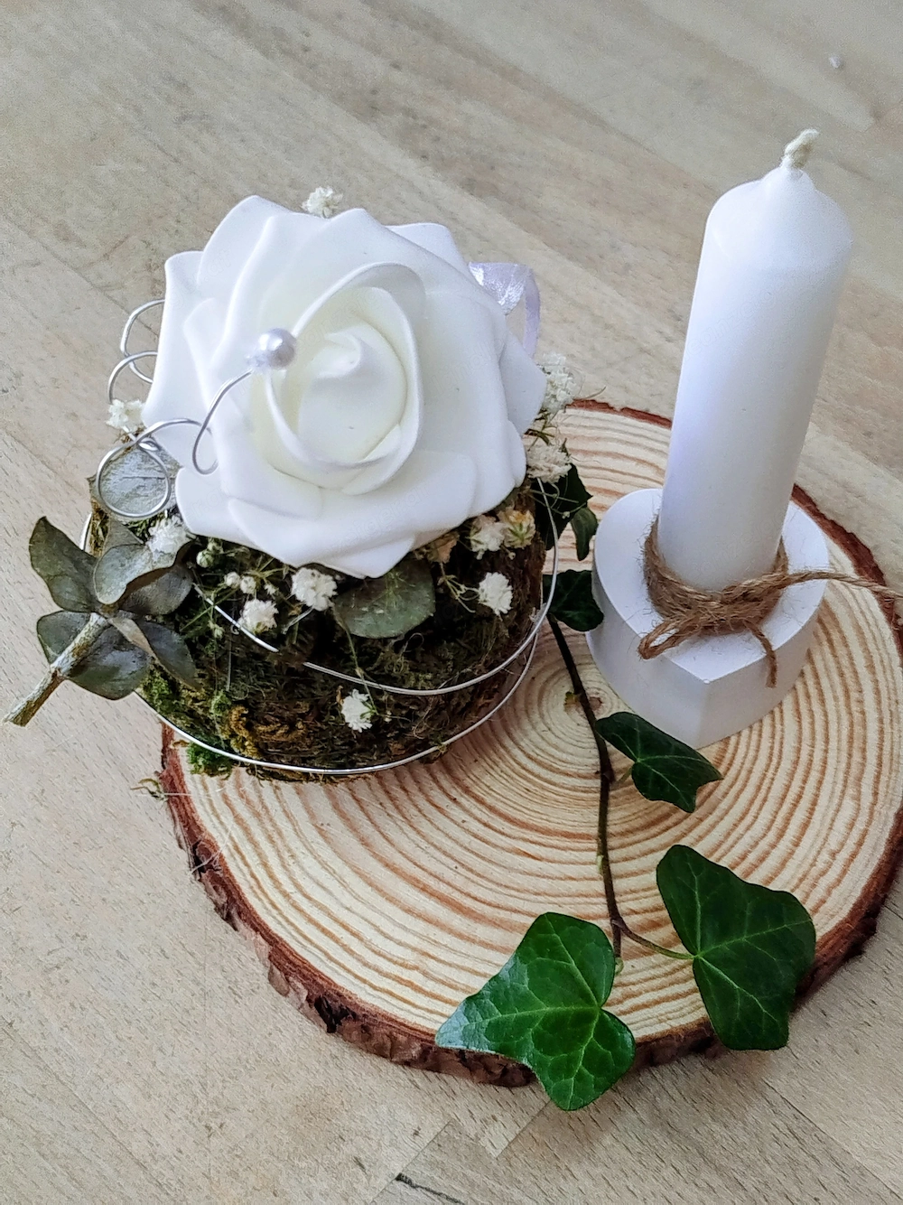 Kerzenständer mit Kerze und Blume auf Holz 