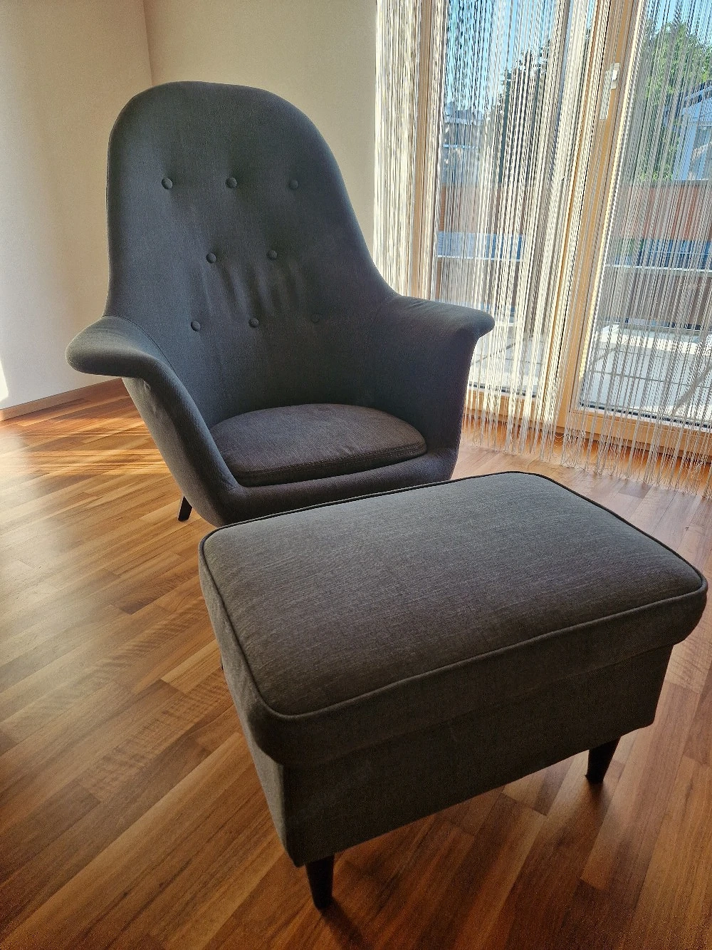 Grauer Ohrensessel mit Hocker
