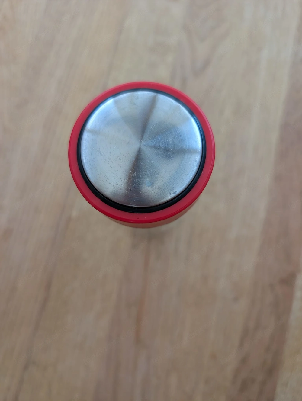 Trinkflasche aus klarem Glas mit einem roten Schraubdeckel.
