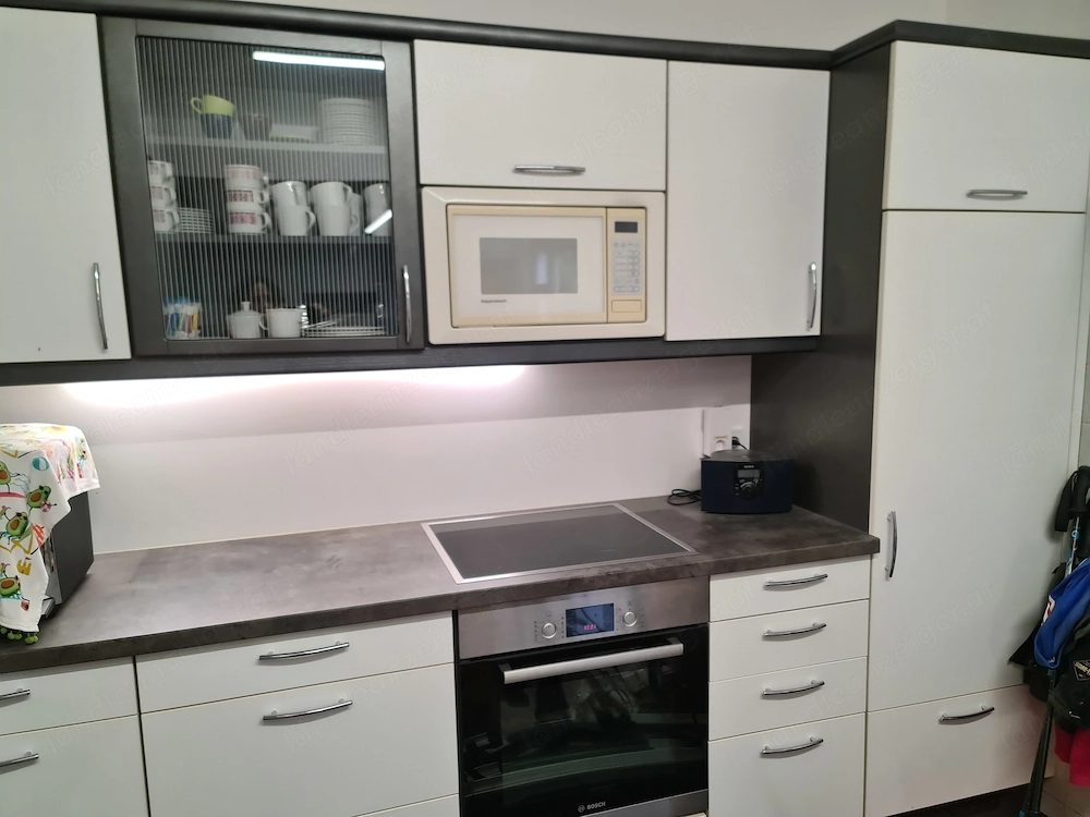 Einbauküche mit Herd, Kühlschrank und Mikrowelle