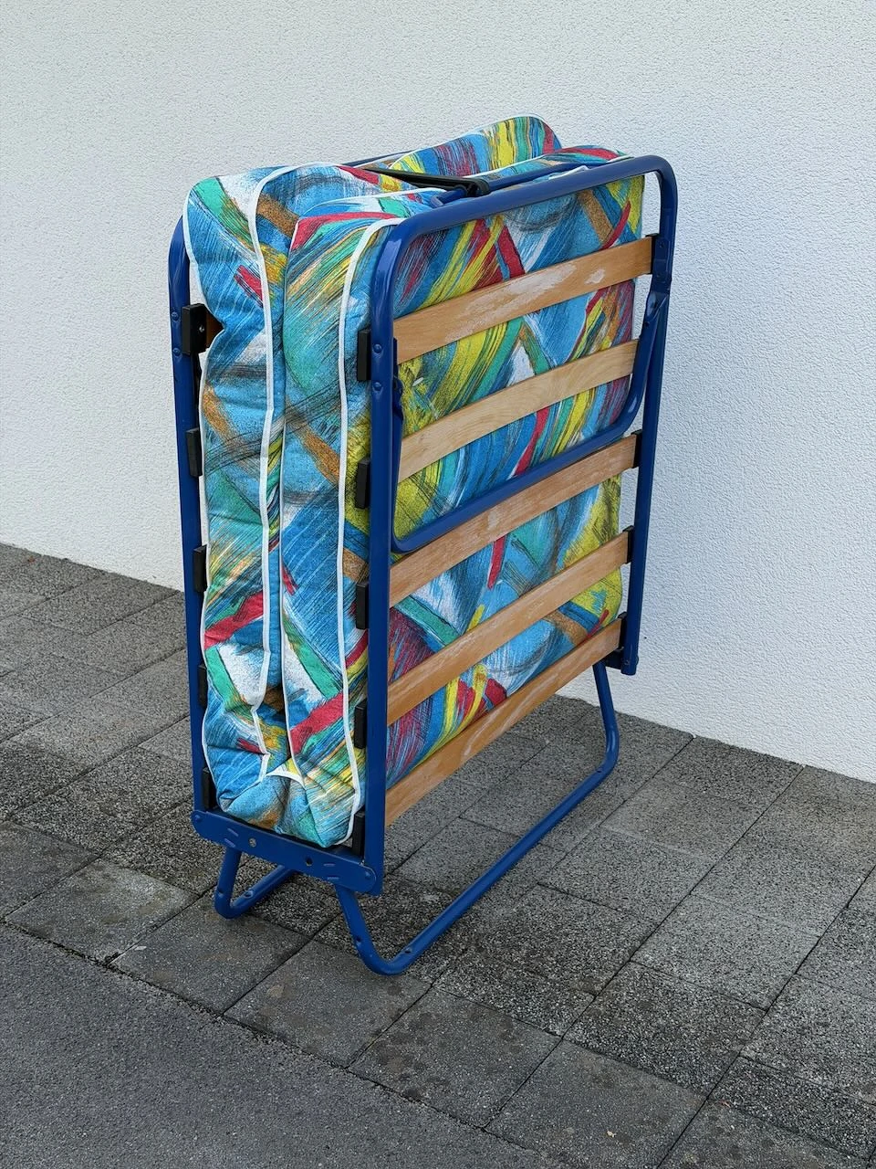 Blaues Klappbett mit fröhlicher Matratze