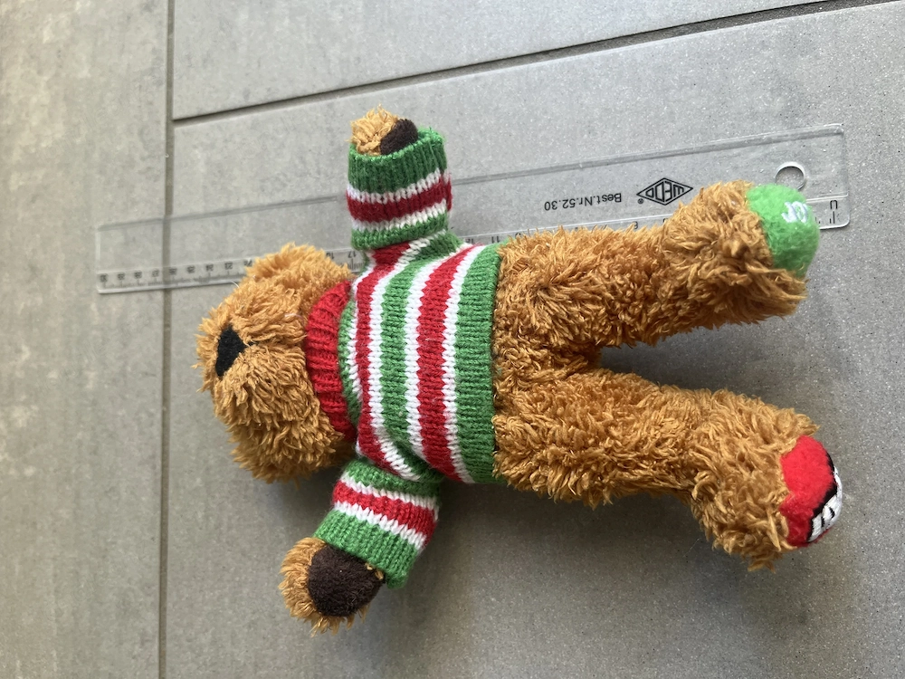 Kuscheliger Teddybär mit gestricktem Weihnachtspullover