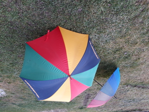 Zwei große regenbogenfarbige Regenschirme Bild 1