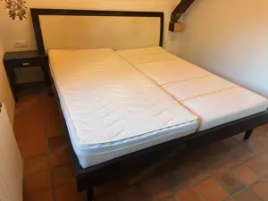Bett mit Nachtkästchen und Bank