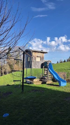 Spielhaus mit Schaukelstangen und Sandkasten