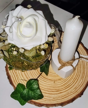 Kerzenständer mit Kerze und Blume auf Holz 