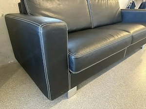 Hochwertiges Design-Kunstledersofa (Schwarz) mit Hocker & Kontrastnaht - Guter Zustand!