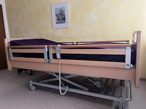 Elektrisches Pflegebett mit Beistelltisch 